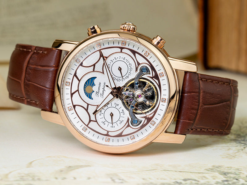 Thomas Tompion Kew Watch with brown strap, bronze casing and white dial. The watch has two subdials with the days of the week and months on the face.