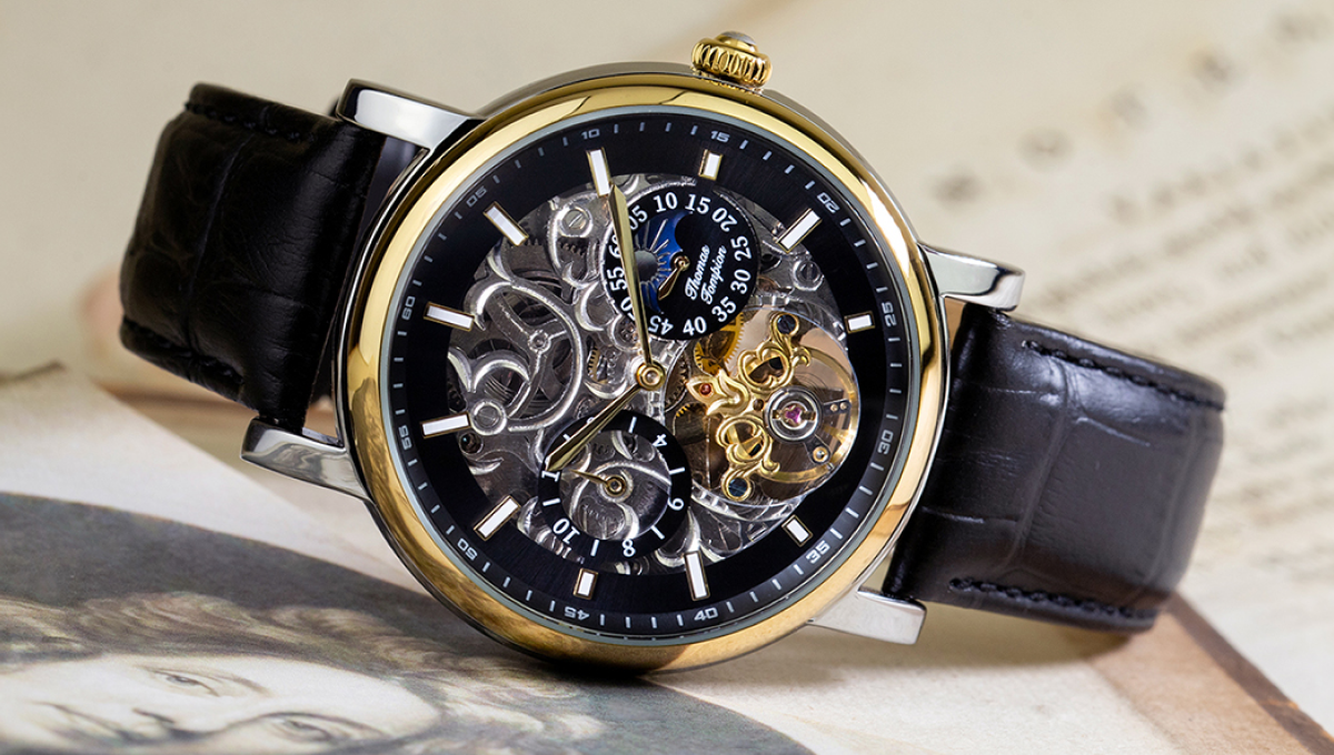 Black watch with two subdials. The clockwork mechanism is exposed under the watch dial.