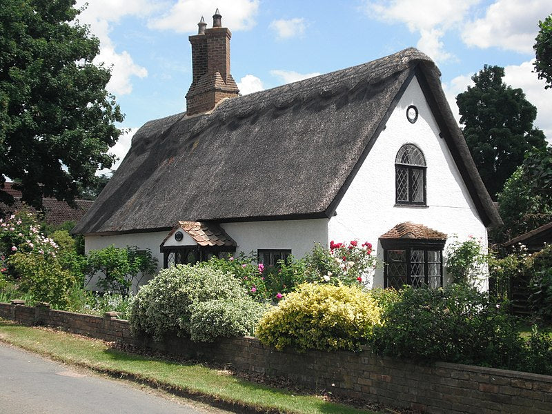 White cottage with black thatched roof